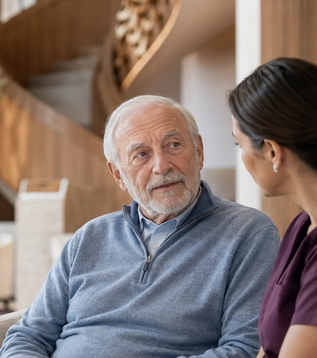 A Vivo Healthcare nurse sitting with a resident, mid-conversation, in the lobby